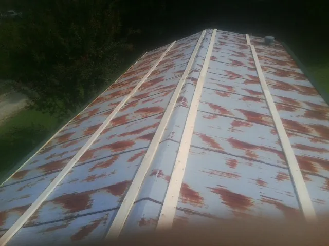 Rusted metal roof panels with new wood purlins before replacement — Storm Damage Roof Repair in Eagle Lake by Roofing Brothers