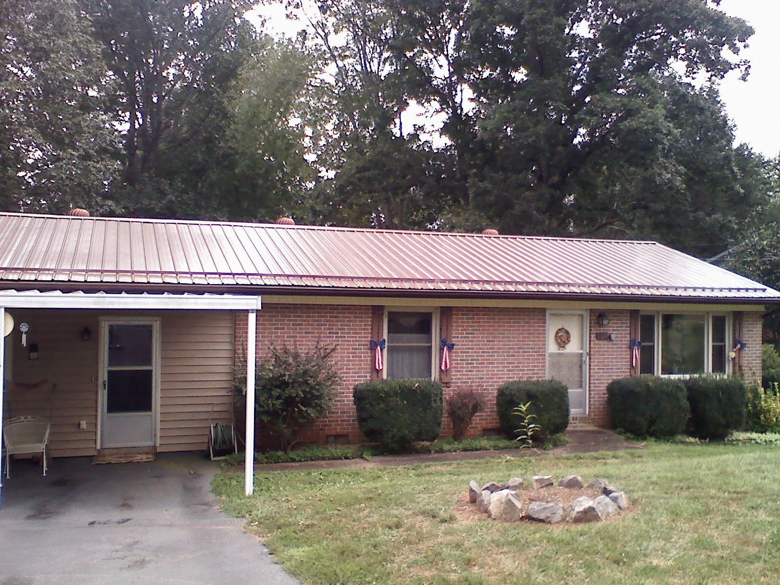 Bronze metal roof and carport on a brick ranch home — Roof Repair work by our crew in Eagle Lake